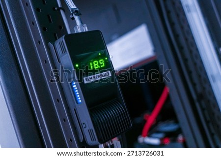 A digital temperature sensor display mounted in a rack system showcasing precise environmental monitoring. Ideal for technology and industrial applications.