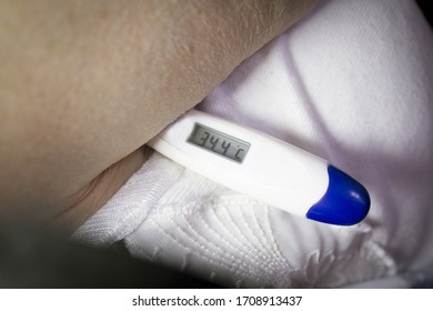 Digital Thermometer Measuring Temperature To Old Woman In Armpit