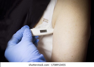 Digital Thermometer Measuring Temperature To Old Woman In Armpit