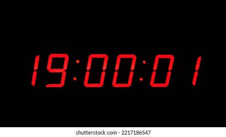 Digital timer on a black background. Light panel with red numbers