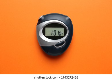 Digital timer on orange background, top view