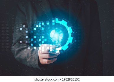 Digital transformation concept. Hand holding light bulb modern interface futuristic blue gear digital and binary coded background. Connection next generation technology and new era of innovation.  - Powered by Shutterstock