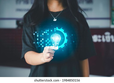 Digital transformation concept. Hand holding light bulb modern interface futuristic blue gear digital and binary coded background. Connection next generation technology and new era of innovation. 