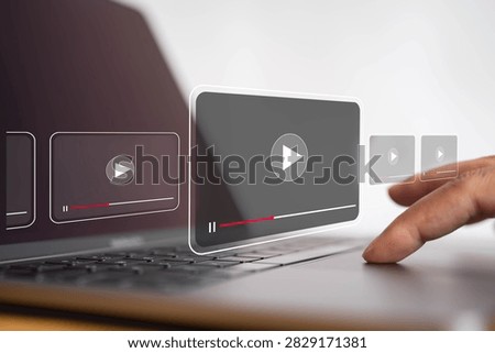 Digital video streaming interface with play buttons over laptop as user interacts with online media, representing video content, multimedia technology, entertainment and online playback.