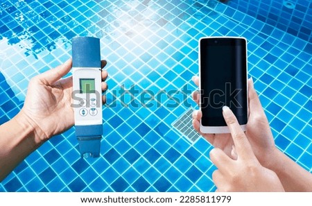 Digital water tester and smartphone in girl hand over clear swimming pool background, online test result, swimming pool maintenance and service concept, new water tester technology