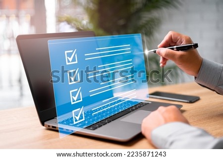 Digital work checklist on virtual screen concept, Businessman use a pen point on checklist and use laptop working in office Document Management System and process automation to efficiently manage file