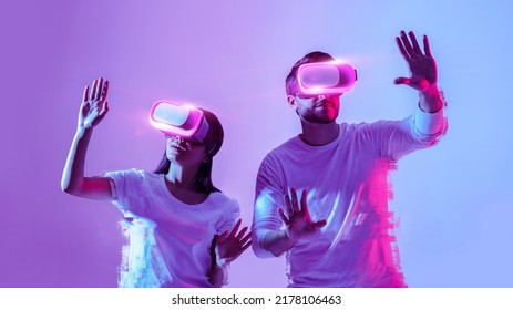 Digital world, newest technologies for entertainment concept, collage. Young couple in white t-shirts using modern virtual glasses, making hands movements isolated in neon, studio shot, panorama - Powered by Shutterstock