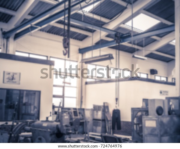 digitally blurred background image of\
blur garage workshop environment with some mechanical stuffs in\
blurry vision as background for backdrop or text copy\
space