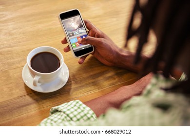 Digitally generated image of video player with various icons against cropped image of man using smart phone