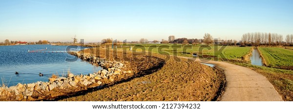 Dike\
reinforced with rubble to protect the shoreline, a raised clay-bar\
to prevent water from washing over the\
dike