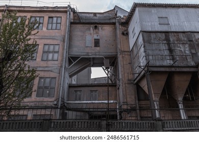 Dilapidated buildings, broken windows, cloudy sky, desolation, decay, industrial decline, urban exploration. - Powered by Shutterstock
