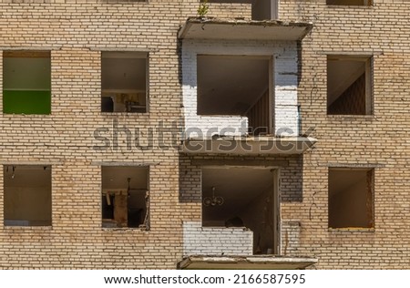 dilapidated house with empty windows against blue sky