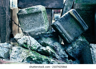 A dilapidated pile of mossy, fractured cinderblocks