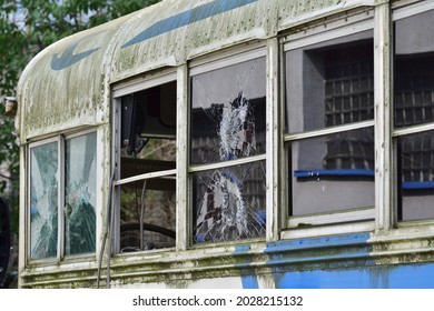 Dilapidated and rusty bus with broken windows in a remote area. Scrap.