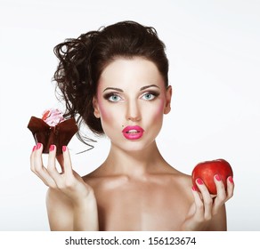 Dilemma. Diet. Undecided Woman with Apple and Cupcake - Powered by Shutterstock