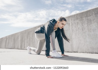 Diligent Athletic Young Girl Getting Ready To Run Long Distance Outdoors