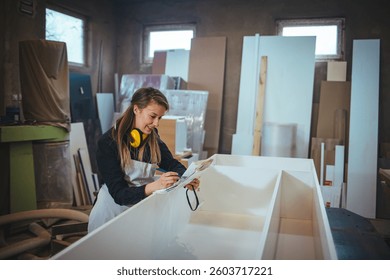 A diligent carpenter in a workshop takes measurements and notes for custom furniture pieces, surrounded by tools and materials, embodying creativity and craftsmanship.