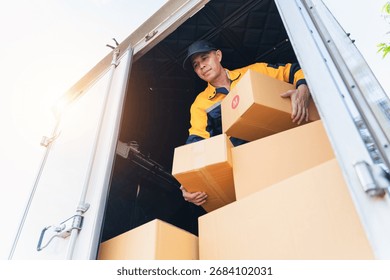 A diligent delivery worker is actively unloading cardboard boxes from a truck in a sunny setting, emphasizing the dedication and efficiency of logistics at work.