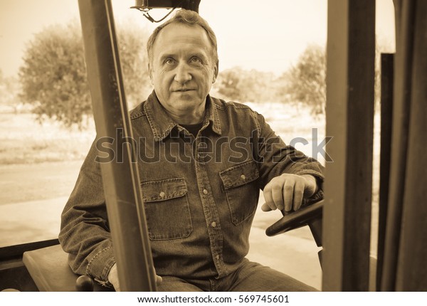 Diligent\
positive elderly man of winery goes on\
loader