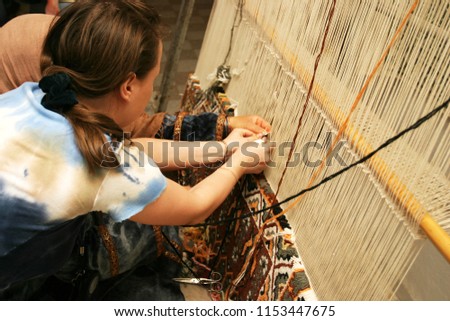diligent woman makes a traditional carpet by hand, oriental ornament, Tunisia
