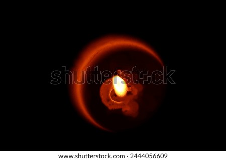 Dim Candle fire in dark with a crerrssed moon