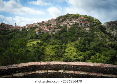 Dimitsana, a picturesque mountain village in Arkadia region, Peloponnese, Greece, nestled on a green hillside with traditional stone houses and red-tiled roofs. - Powered by Shutterstock