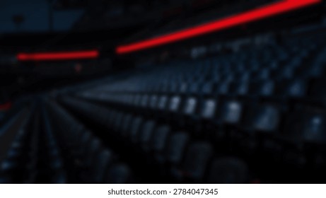 A dimly lit auditorium with rows of empty seats, creating a sense of anticipation. The red lighting adds a dramatic effect to the scene.