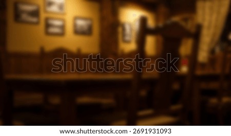 Dimly lit interior of a rustic dining area features wooden furniture under warm artificial light
