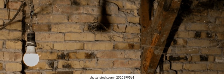 A dimly lit light bulb hanging from the ceiling of a neglected room, representing the concept of decay and abandonment - Powered by Shutterstock