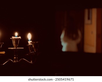 A dimly lit scene featuring two burning candles on a candelabra, with a blurred background that appears to show a person walking down a hallway.
The atmosphere is mysterious and cinematic. - Powered by Shutterstock