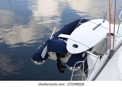 Dinghy And Surfboard Hooked On The Stern Of Yacht.