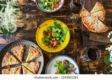 Dining Al Fresco. Dinner Table With Vegetable Salad And Pizza. Eating Outside. Summer Food On Wooden Table, Overhead View.