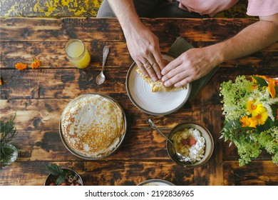 Dining Al Fresco Or Healthy Breakfast Outside. Man Eating Crepes Rolls With Curd. Food On Wooden Table Overhead View.