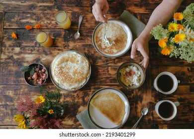 Dining Al Fresco Or Healthy Breakfast Outside. Man Eating Crepes Rolls With Curd. Breakfast Food On Wooden Table, Top View.