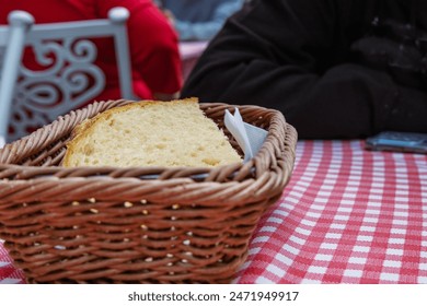 Dining out in the Grand Mothers Slovakian restaurant in Bratislava. Slices of white bread in the basket on the table with white red checkered tablecloth. Table outside on the street. Selective focus - Powered by Shutterstock