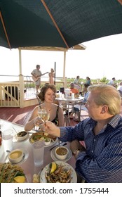 Dining Outside On The Deck Of A Bayside Restaurant