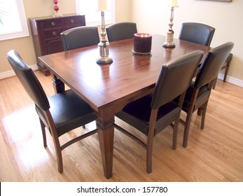 Dining Room With Dark Wood Table, Six Chairs, Candelabra And Two Windows With A Natural Wood Floor.