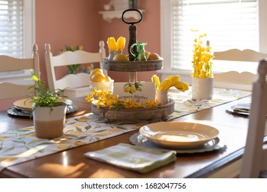 Dining room table styled for spring with yellow flowers and lemons - Powered by Shutterstock