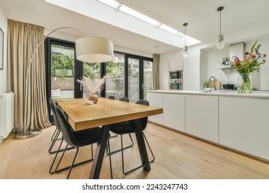 a dining room with wood flooring and skylights above the kitchen area in an open - plan living space - Powered by Shutterstock