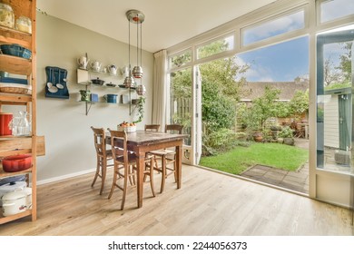 a dining room with wood flooring and sliding glass doors that open onto the backyard patio area, where there is an outdoor kitchen - Powered by Shutterstock