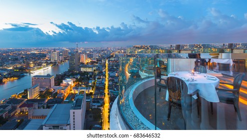 Dining Table With Beautiful City View On Rooftop At Twilight Scene