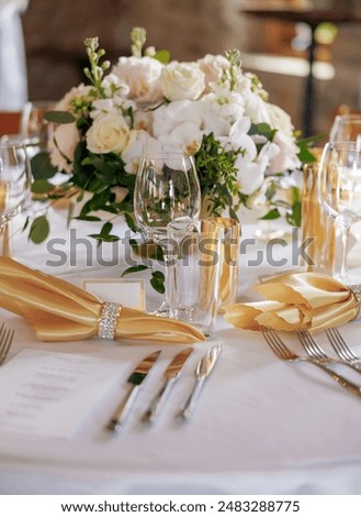 Dining table with beautiful table settings and floral decorations. Beautifully decorated table in a restaurant. Silver cutlery, fresh flowers and clear glasses decorate the table in a restaurant