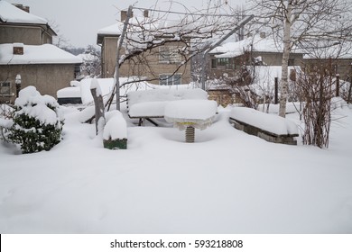 Dining Table With Benches And Rest And Talk In Good Weather, Vine And Birchwood Amid Houses Buried By Snow