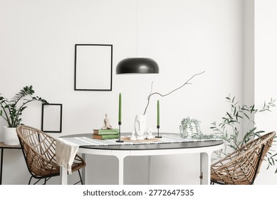 Dining table with burning candles, tree branch and books in light room
