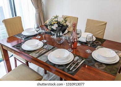 dining table and comfortable chairs in modern home with elegant table setting 