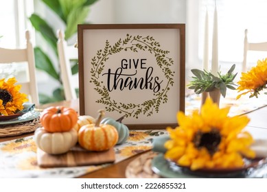 Dining table decorated for fall with a sign that says give thanks