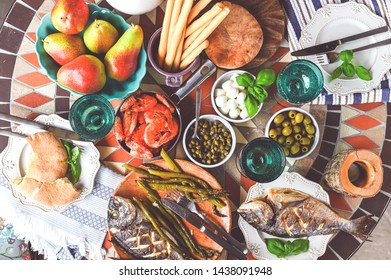Dining table with different food and snacks. Seafood and vegetable. Summer lunch in the open air. View from above.  Flat lay.