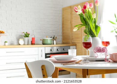 Dining Table With Setting And Glasses Of Wine For International Women's Day Celebration In Kitchen