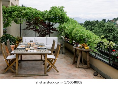 dining table with wooden chairs set on the terrace with beautiful italian landscape. food concept