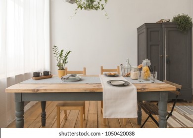 dining wooden table and chairs in modern home with elegant table setting